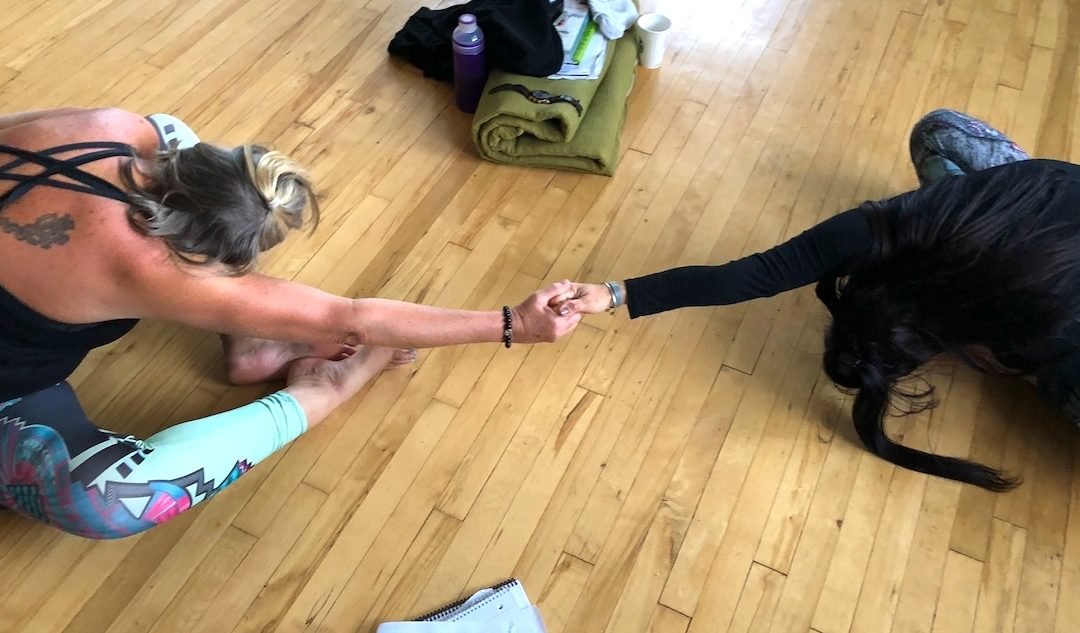Yin yoga students assist each other