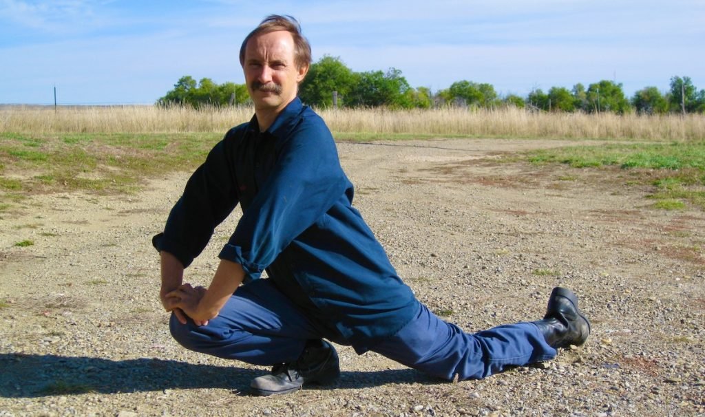 A Lesson in Yin Yoga from Founder Paulie Zink | Elephant Journal, 2016 Paulie Zink doing advanced Yin yoga pose in leather work boots on rocky ground
